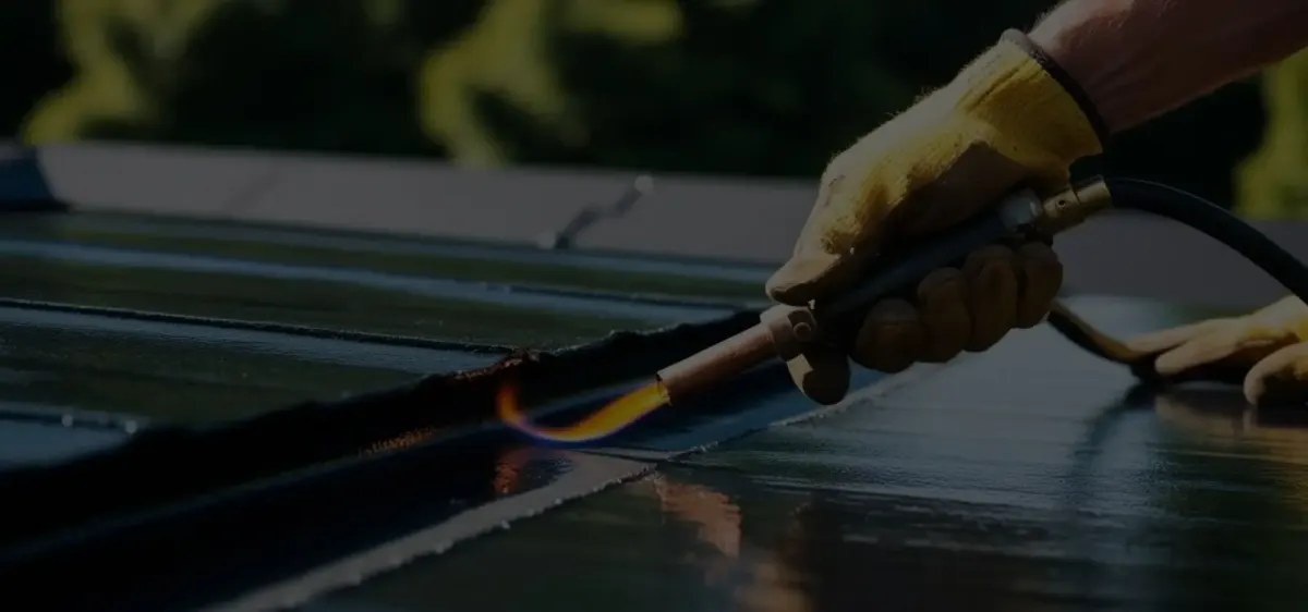 Dakdekker legt bitumen dakbedekking met een brander
